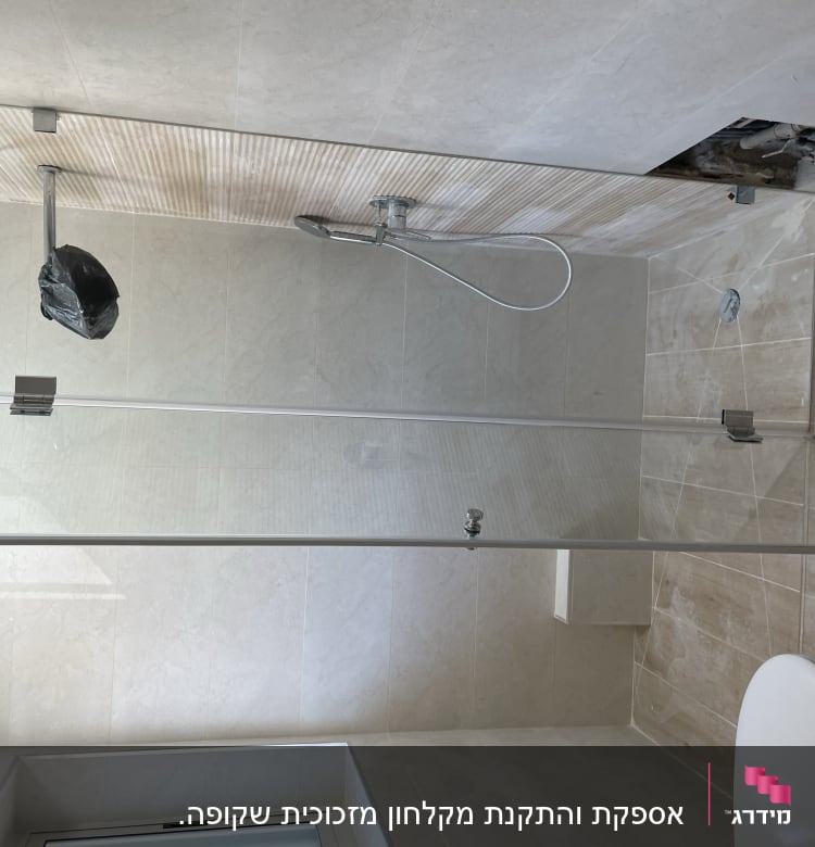 מקלחת עם דלת זכוכית וברז מקלחת כסוף